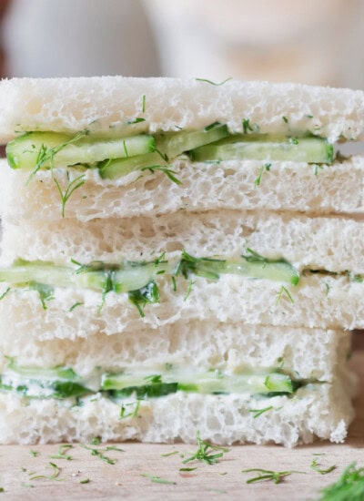 sandwich with white bread and cucumber slices stacked up.