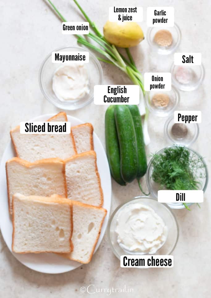 all ingredients for cucumber sandwich on a wooden board.
