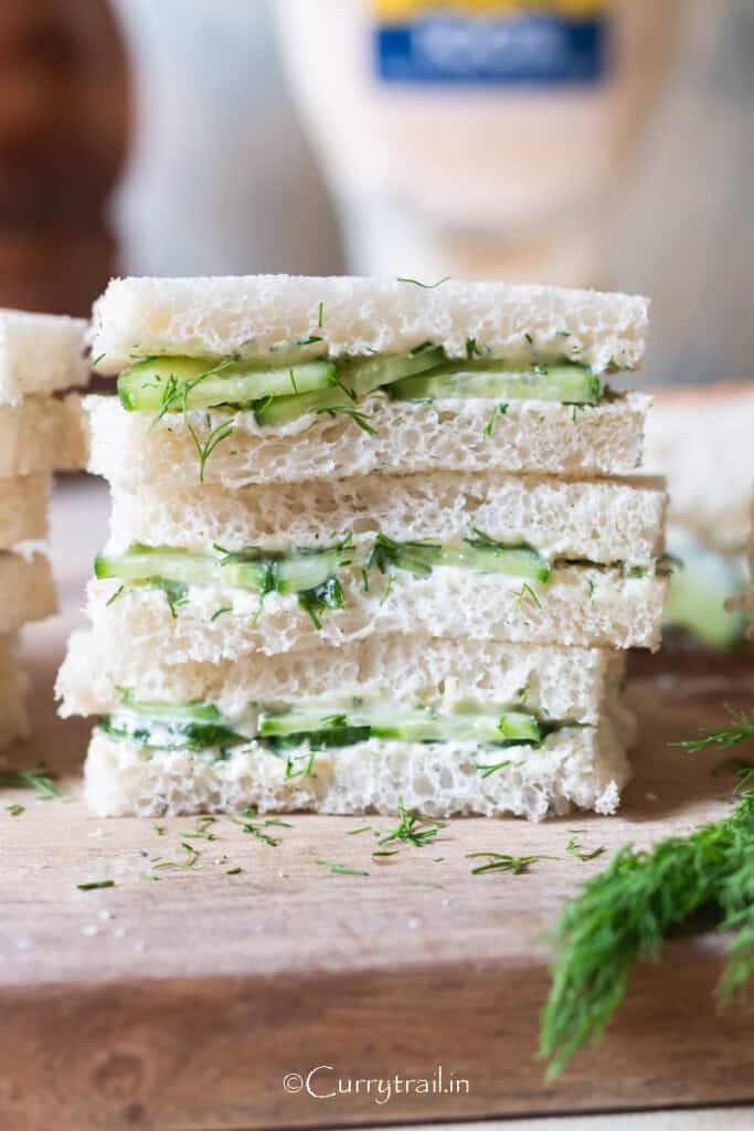 sandwich with white bread and cucumber slices stacked up.