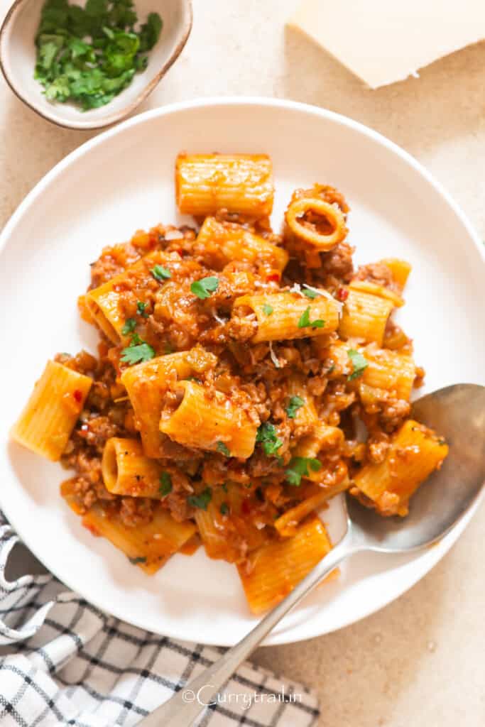 pasta in lamb bolognese sauce served on plate.
