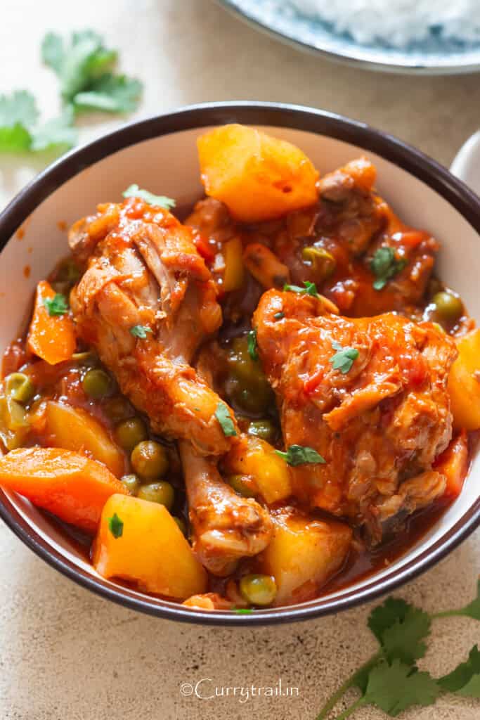 chicken thighs and drumsticks with potatoes and carrots in tomato-based stew.