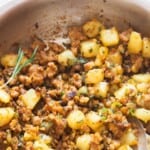 lamb and potatoes in a skillet with fresh rosemary.