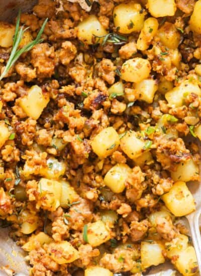 lamb and potatoes in a skillet with fresh rosemary.