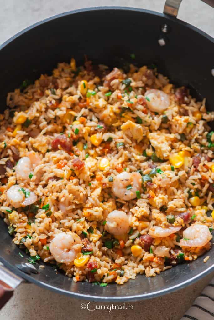 Vietnamese style fried rice in a wokl with green onions on the side.