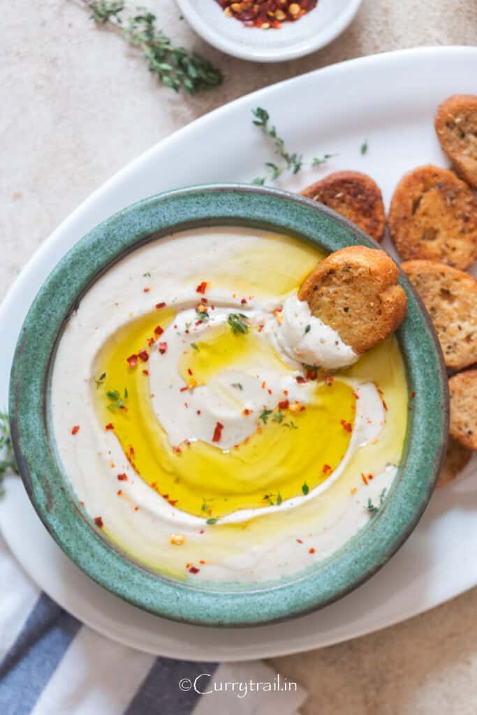 white bean dip with extra virgin olive oil and fresh thyme topping.