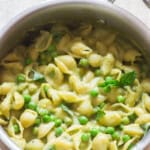 shell pasta with peas cooked in a large pan.