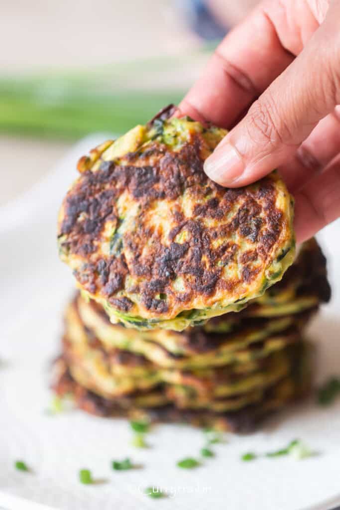 holding a golden brown crispy fritter.