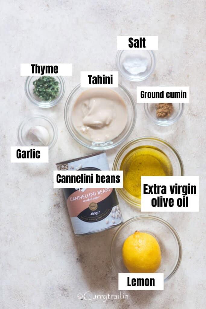 all ingredients for canned cannellini bean dip are arranged on a table.