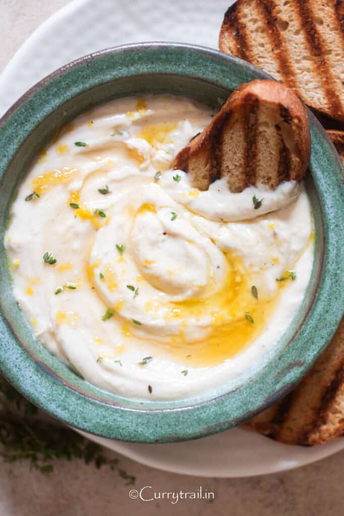 creamy whipped ricotta cheese appetizer with crostini bread dipped in.