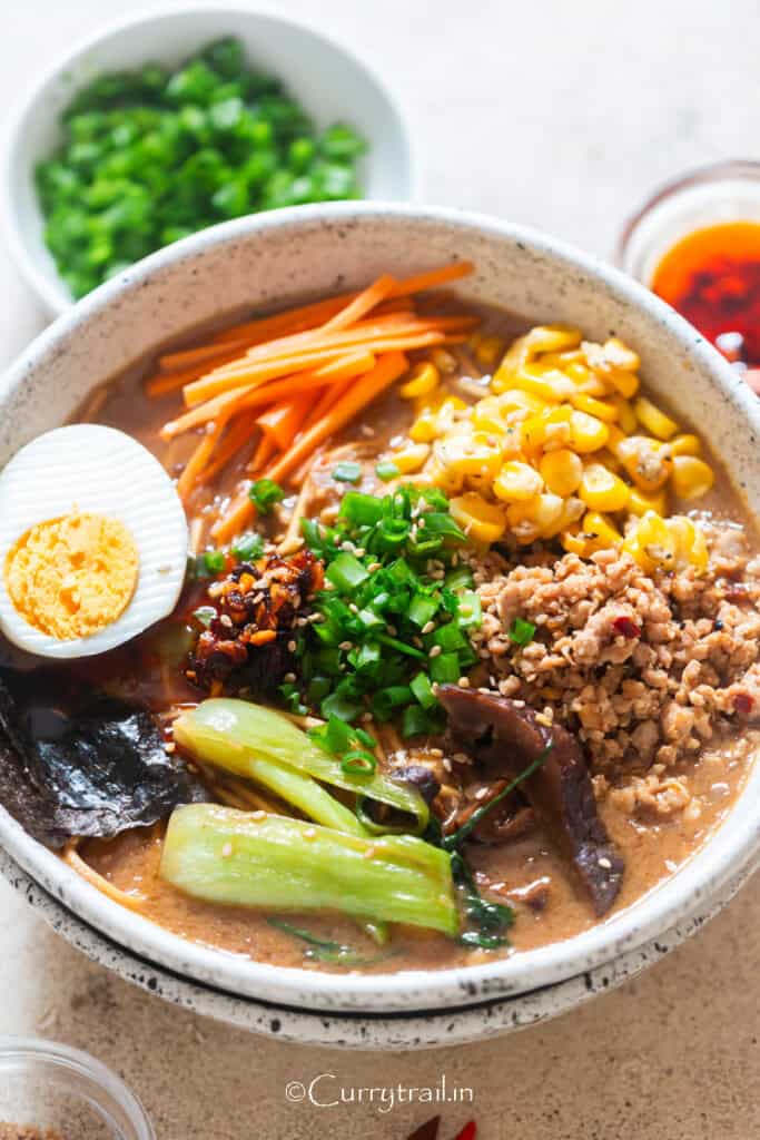 spicy miso ramen in umami broth with lots of toppings in a bowl.