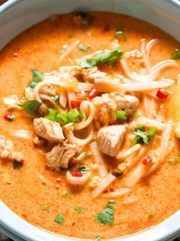 Thai soup with chicken and rice noodles in a bowl.