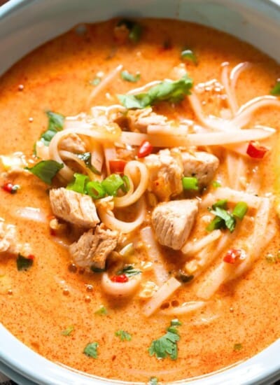 Thai soup with chicken and rice noodles in a bowl.