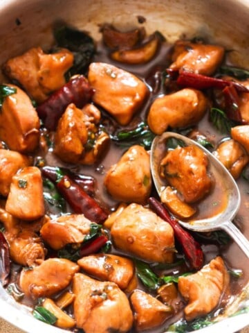 saucy chicken cooked in soy sauce chinese wine and sesame oil in a skillet.