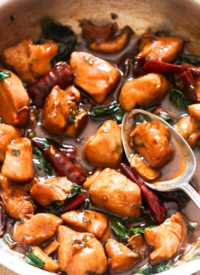 saucy chicken cooked in soy sauce chinese wine and sesame oil in a skillet.