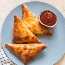 golden puff pastry filled corn spinach puffs on a plate.