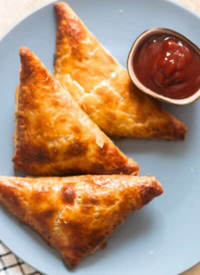 crispy golden corn spinach puffs on a plate with ketchup on the side.