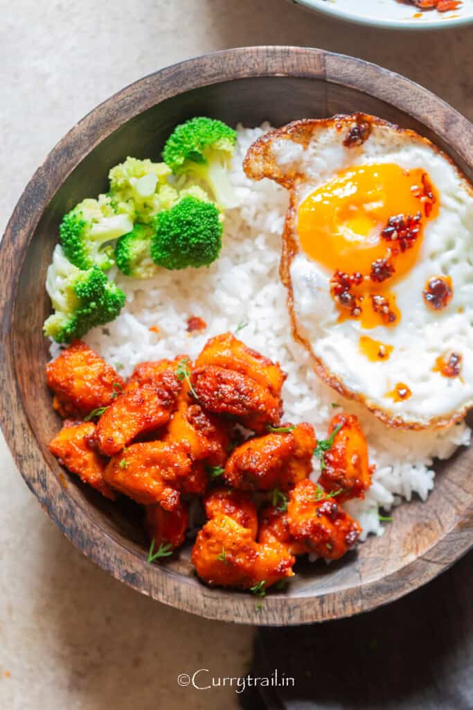 healthy juicy air fryer salmon bites served with jasmine rice and fried eggs in a bowl.