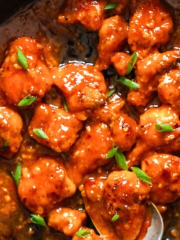 spicy boneless chicken cooked with buffalo hot sauce in a skillet.