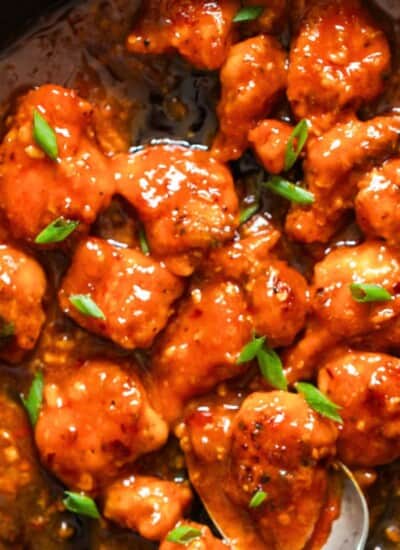 spicy boneless chicken cooked with buffalo hot sauce in a skillet.