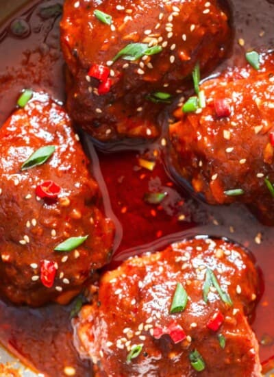 chicken thighs glazed with gochujang sauce and garnished with green onion, sesame seeds and few fresh red chilies.