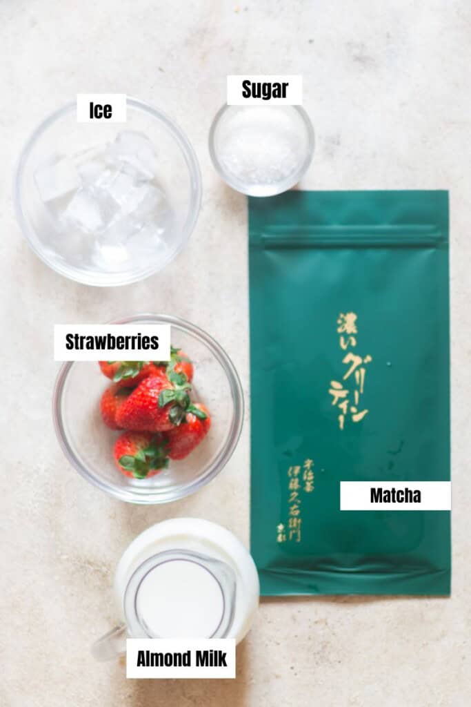 all ingredients for strawberry matcha latte arranged on a table.
