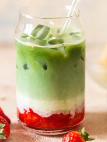 drinking glass with crushed strawberries and matcha tea with milk in 3 layers.