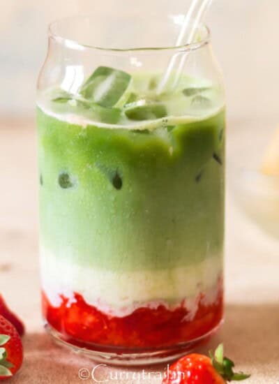 drinking glass with crushed strawberries and matcha tea with milk in 3 layers.