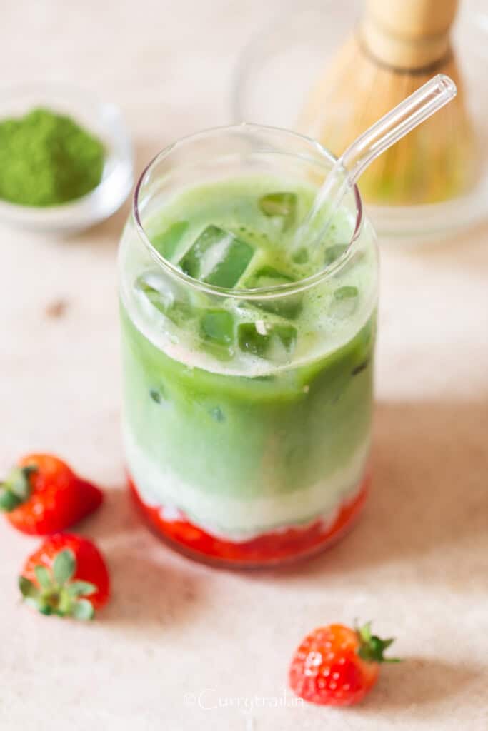 strawberry matcha latte in tall drinking glass.