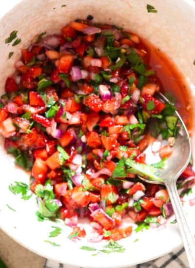 fresh strawberry salsa in a bowl with a spoon.