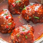 spicy glazed chicken thighs with gochujang sauce cooked in a skillet.
