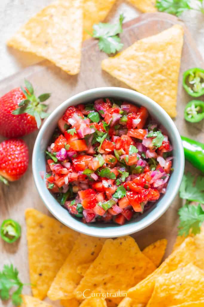 fruit salsa in a bowl with nachos on the side.