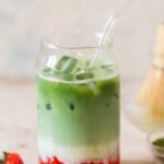 3 layers of strawberry puree, milk and matcha tea in a drinking glass.