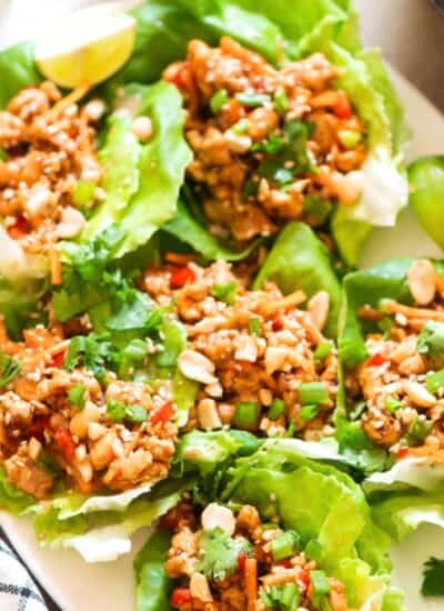 lettuce cups filled with ground chicken and toppings on a plate.