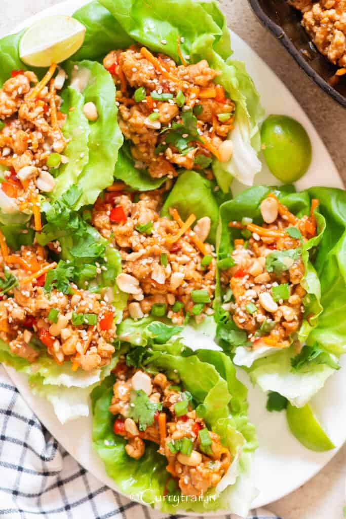 lettuce cups filled with ground chicken and toppings on a plate.