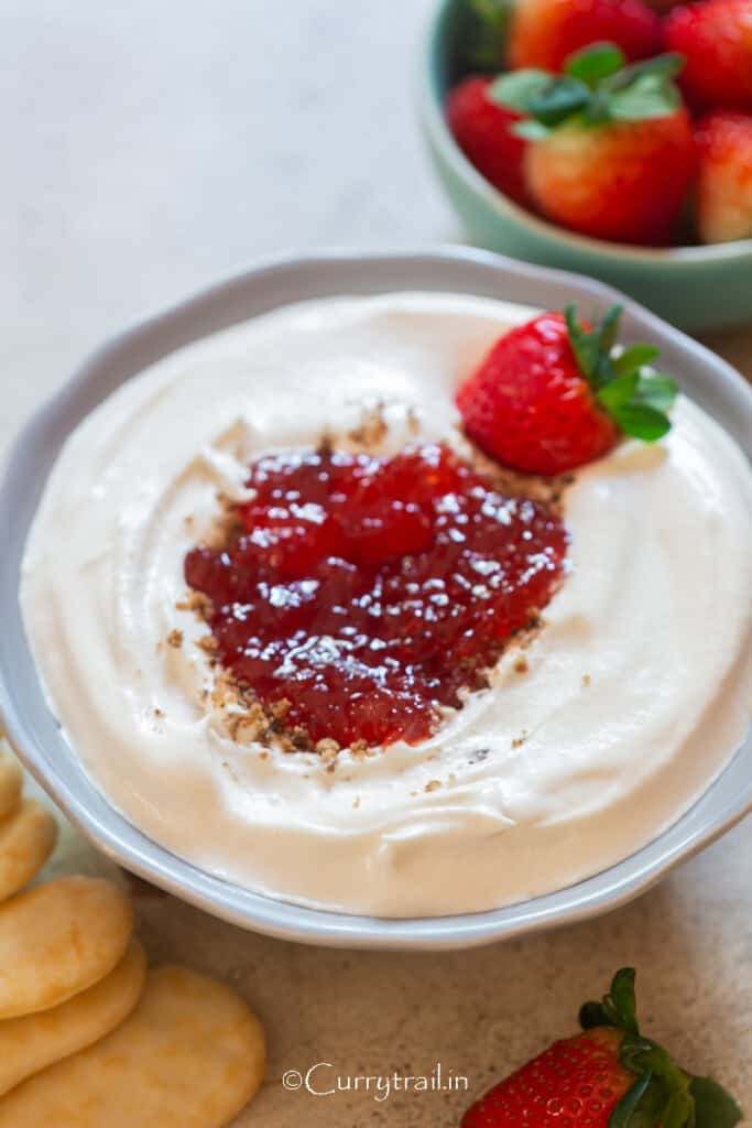 creamy cheesecake dip with berry jam as topping.