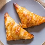 apple pie filled puff pastry with sugar glaze on top.
