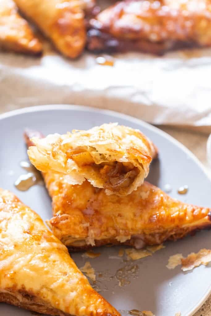 apple turnovers made using puff pastry with sugar glaze on top.