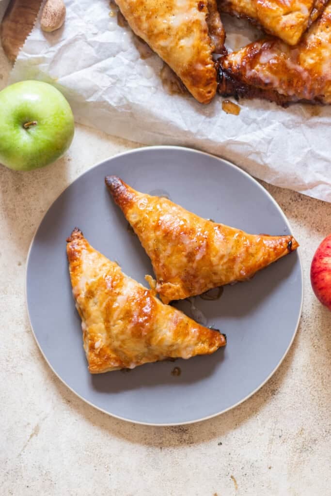 apple turnovers made using puff pastry with sugar glaze on top.